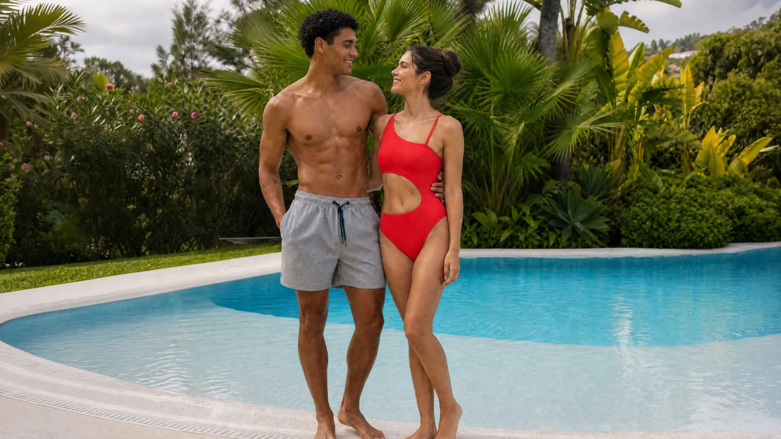 KI-generiertes Kampagnenbild für bruno banani Bademode: Paar am Pool, sie im roten Cut-out-Badeanzug, er in gestreifter Badeshort